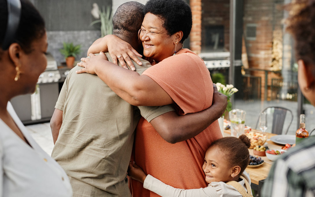 Man, woman, and child hugging in celebration