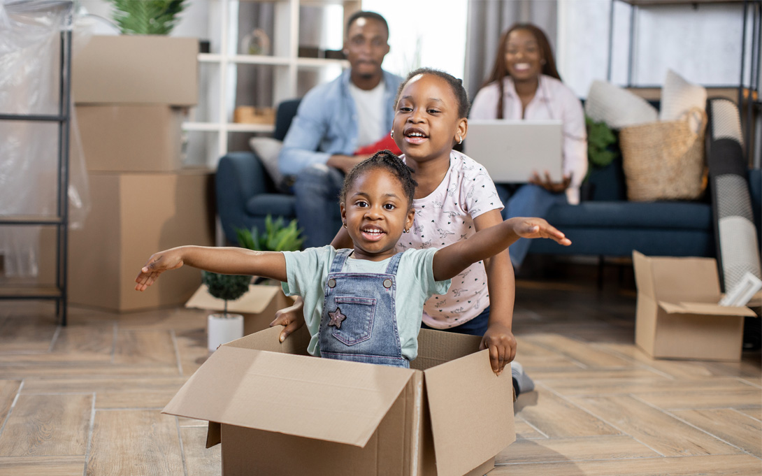 Image of a family with two children playing in moving boxes