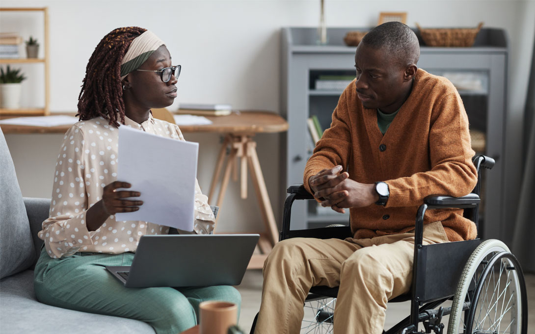 Man in a wheelchair getting assistance