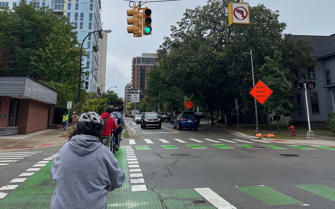 Bike riders moving through traffic in Ann Arbor, Michigan