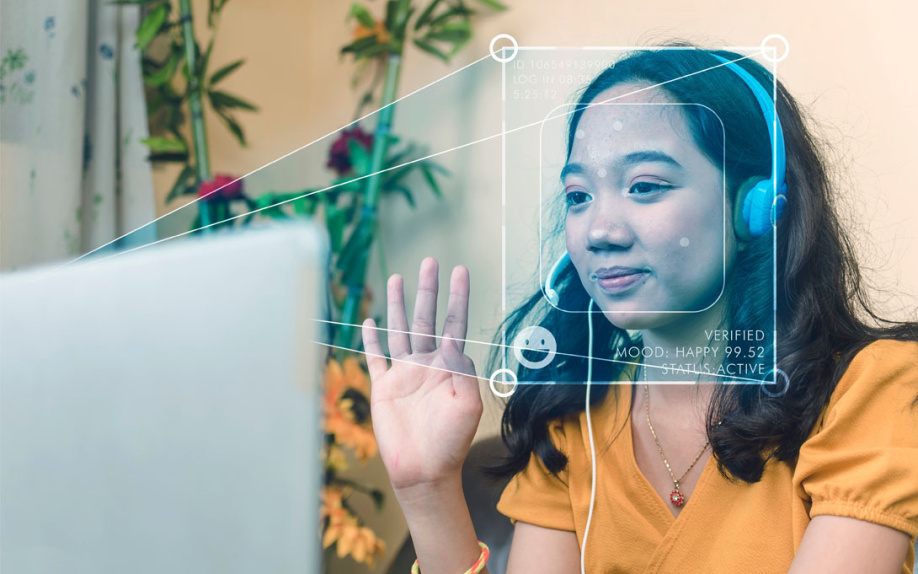 Woman sitting at PC with projection of face scan